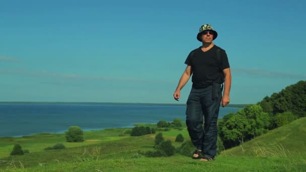 A man with a backpack who was admiring the lake from the mountain. — Stock Video