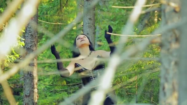 Een vrolijke jonge heks in zwarte kleding wervelingen rond in de dans in het forest. Halloween. Gotische stijl. — Stockvideo