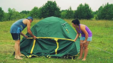 Bir erkek ve bir kadın bir metal ark çadır bezi ekleme.