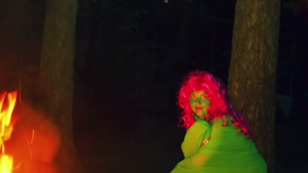 Зеленая ведьма, сидящая у огня, поднимается . — стоковое видео