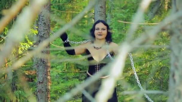 A young witch in black clothes tied with chains. Halloween. Gothick style. — Stock Video