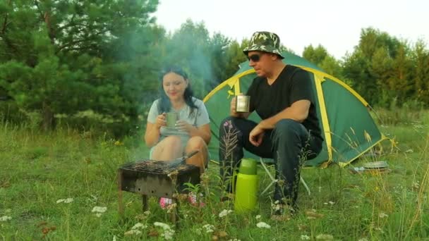 一个男人和一个女人在帐篷附近的烧烤炉上煮肉 总体规划 — 图库视频影像