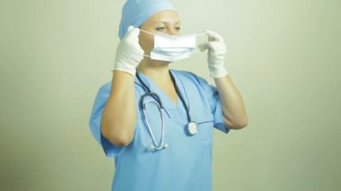 Bir kadın doktor tıbbi yüz maskesi koyar.