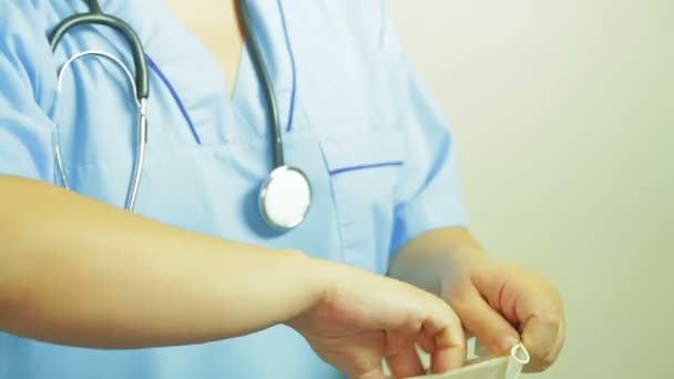 Γιατρός γυναίκα βάζει Ιατρικά γάντια στα χέρια πριν την επέμβαση. — Αρχείο Βίντεο