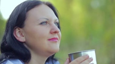 mutlu genç kadın kupa çay içer.