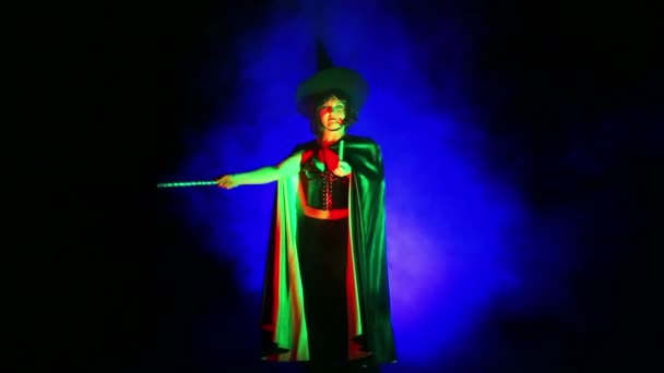 煙の中で魔女を装って、サーチライトの光の若い女性. — ストック動画