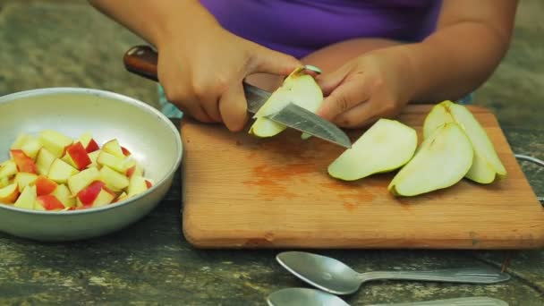 Kvinnliga händer rengör päron från kärnan för fruktsallad. — Stockvideo