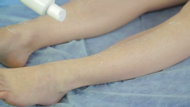 Jeune femme médecin esthéticienne met sur la peau des pieds d'une fille talc . — Video