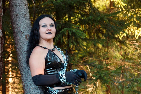 Bir genç kadın cadı bir ormanda zincirlenmiş siyah yakın çekim. Cadılar Bayramı.