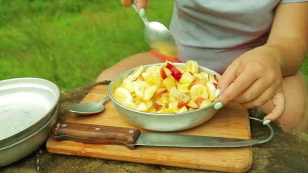 Bir kadın bir meyve salatası pikniğe kaşıkla kıpırdanırken. — Stok video