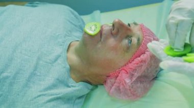 elinde makyajcısı kadın adamın yüzünde maske kivi koymak.