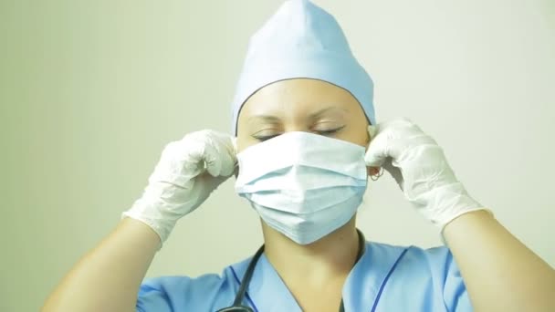 Un medico donna rimuove una maschera medica dal suo viso . — Video Stock