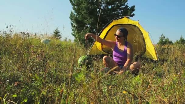 Una Donna Con Gli Occhiali Sole Seduta Vicino Alla Tenda — Video Stock