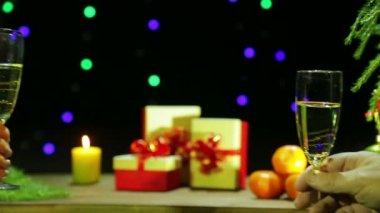 Erkek ve kadın el şampanya bardağı ellerinde tutmak ve onları birlikte bir Noel'de isabet / yeni yıl kutlama.