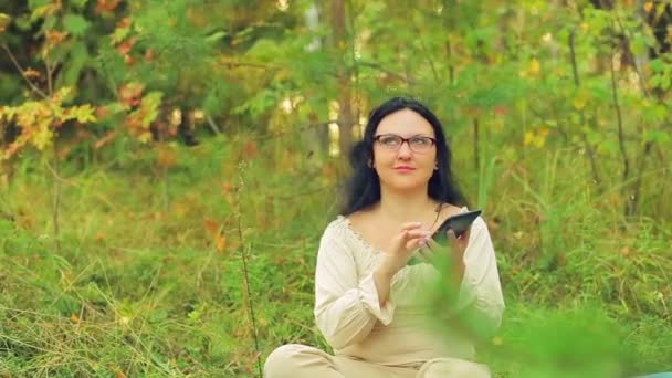 Een Jonge Vrouw Bril Het Bos Zit Het Gras Communiceert — Stockvideo