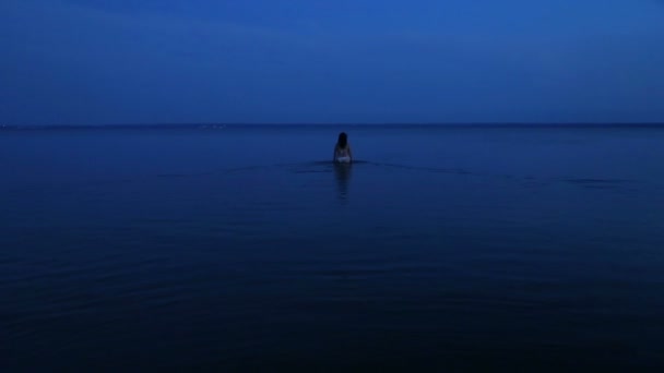 白い水着や衣装の若い女性は 湖を入力します 背面から撮影 — ストック動画