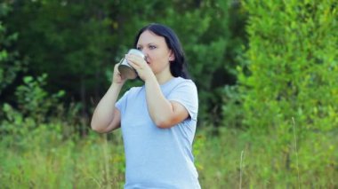 mutlu kadın çay içme ve doğa hayran orman kenarında duruyor.