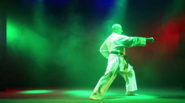 Bir erkek karate renkli duman bir zemin üzerine devreye girer