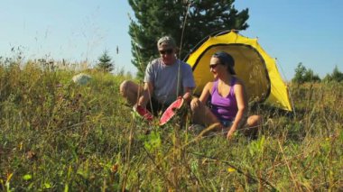 Bir erkek ve kadın bir karpuz kesmek bir çadır yakın:.