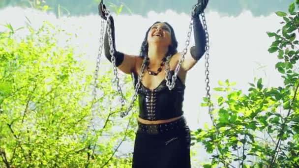 Göl kıyısında siyah giysili bir kadın cadı eğleniyor ve ellerinde zincirler ile dans. Cadılar Bayramı. Gothick tarzı. — Stok video