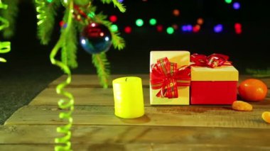Noel hediyeleri Noel ağacı ışıkları siyah bir zemin üzerine mandalina yanındaki masada.