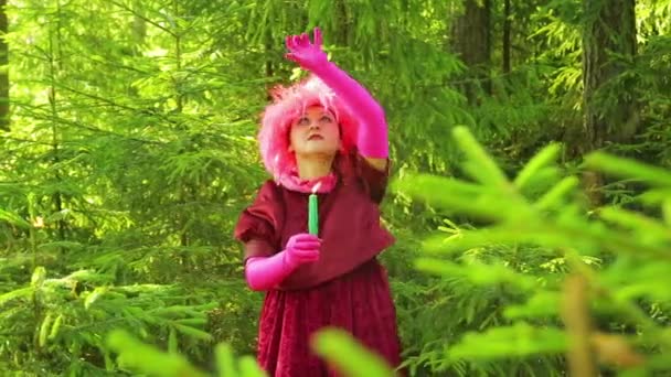 Młodą czarownicę w rytualnym stroju trzyma świecę w ręku i wykonuje rytuał ruchów rękami — Wideo stockowe