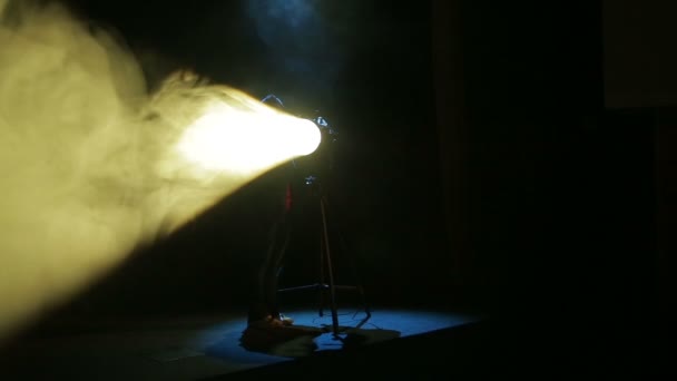 A young woman illuminator profiles a beam of light. — Stock Video