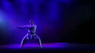 Bir erkekte kimano karate bir arka plan renkli duman nişanlandı