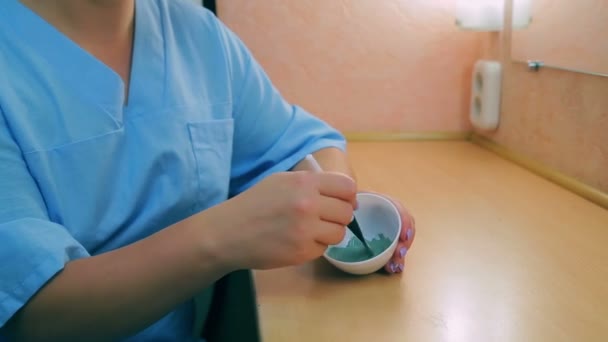 Женщина за столом помешивает маску для лица — стоковое видео