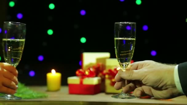 A férfi és a nő ünnepelni Karácsony Szilveszter pezsgőspoharak tarthatnak a kezükben, és nyomja őket össze — Stock videók