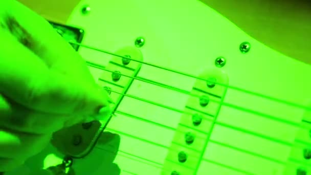 Close-up van een vrouwelijke hand zeven van de snaren van een gitaar met een pick. — Stockvideo