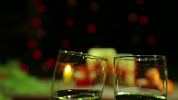 Lunettes avec champagne mousseux se frappent lors de la célébration du Nouvel An de Noël — Video