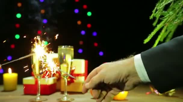 Ein Mann und eine Frau feiern Neujahr, indem sie Wunderkerzen neben dem Weihnachtsbaum anzünden — Stockvideo