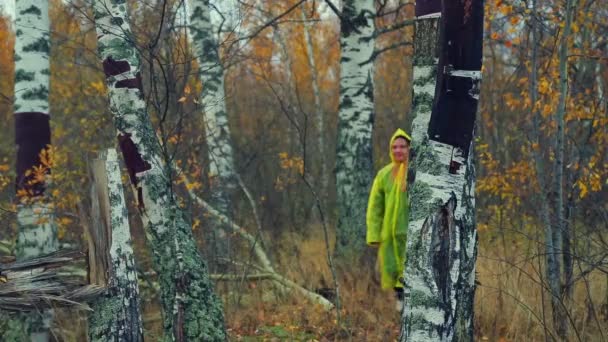 Bir yağmur ceket bir kadında orman geçer. Genel planı. — Stok video