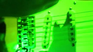 Bir adamın elini elektrik gitar çalıyor. Yakın çekim.