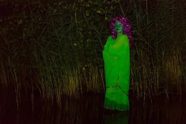 A water witch stands in the lake at dusk.