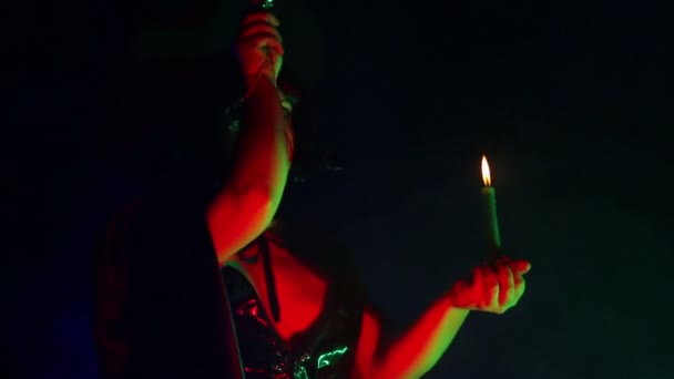 一个年轻女巫的脸, 手里拿着蜡烛读咒语, 用魔杖处理魔术. — 图库视频影像
