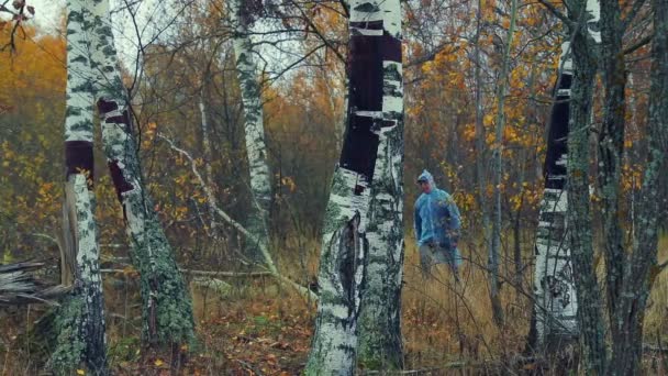 Hombre Con Impermeable Atraviesa Bosque — Vídeos de Stock