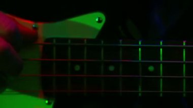 Bir adamın elini bas-gitar çalıyor.