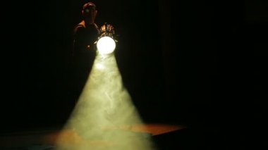 Bir erkek ışığı yukarıya--dan dip profil spot ışık huzmesi yönlendirir.