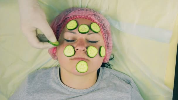 Manos Cosmetólogo Masculino Guantes Quitan Cara Una Mujer Trozos Pepino — Vídeo de stock