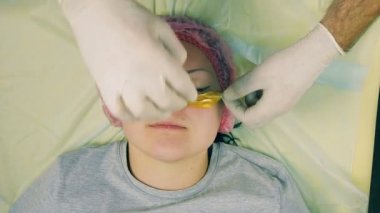 bir erkek güzellik uzmanı eldiven eller kollajen yastıkları kadının yüzünde gözlerinin altında empoze