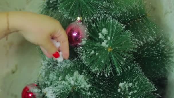 Rouw hand is het versieren van kerstboom met imitatie van sneeuw. Close-up. — Stockvideo