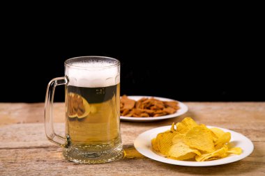 Ahşap bir masaya gevrek kruton ve patates cipsi ile plakalar vardır.