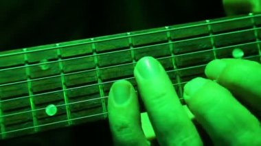 Yakın çekim erkek el tonların üzerine bir elektro gitar alır. Konser aydınlatma.