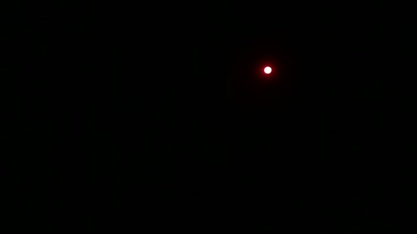 Un faisceau de lumière rouge d'un projecteur dirigé vers la scène dans l'obscurité totale . — Video