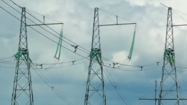 De lijn van de transmissie van de macht bevindt zich op de achtergrond van het runnen van wolken. De camera loopt vanaf de bovenkant van de pijlers naar het algemene plan — Stockvideo