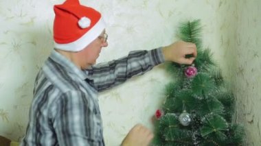 Noel Baba'nın şapkalı adam şenlikli bir top Noel ağacı üzerinde asılı