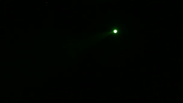 Луч зеленого света от профиля прожектора направленный на сцену в полной темноте — стоковое видео