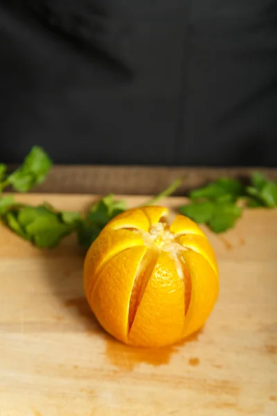 ahşap bir gemide bir portakal yatıyor ve yaprakları yeşillik,